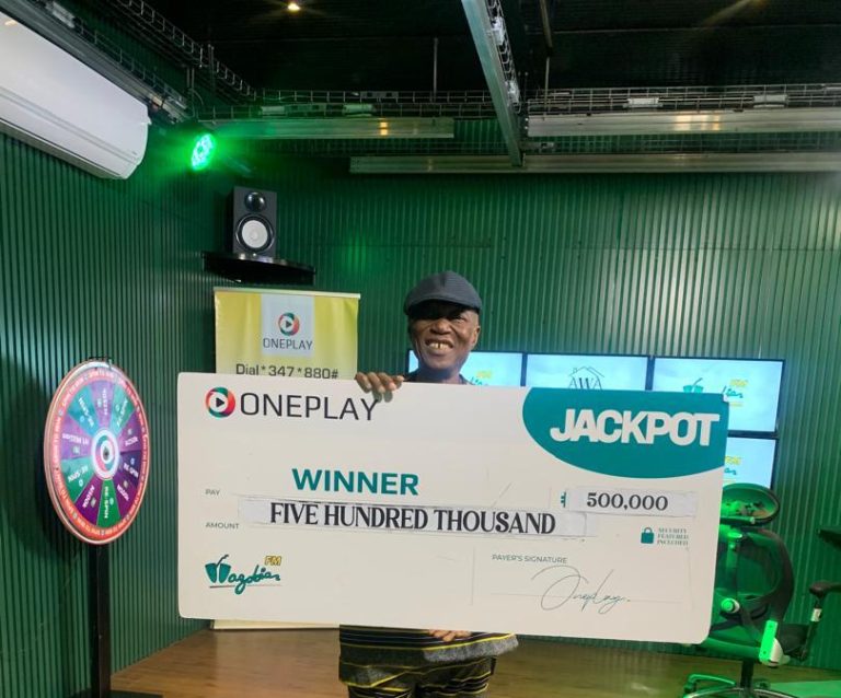 Lawrence holding a ₦500,000 check from Oneplay