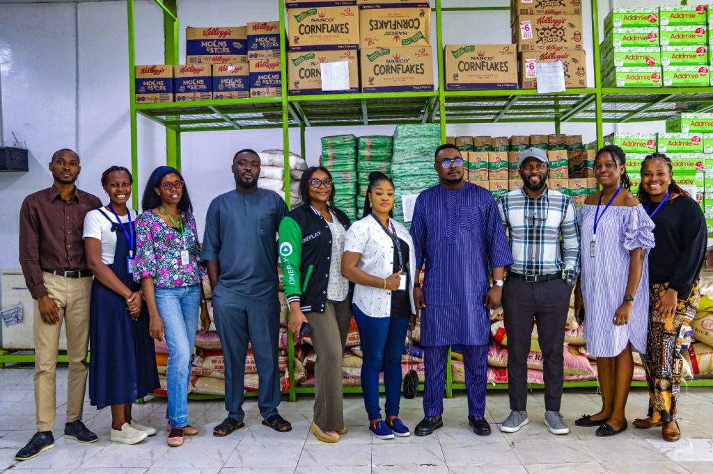 Oneplay staff and Lagos Food Bank team at the Lagos Food Bank warehouse, showcasing their partnership to fight hunger and support communities.